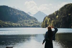 The girl in the dress and hat of the lake in the mountains photo