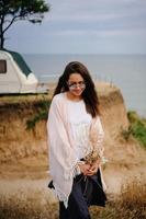 Beautiful, young girl posing on a wild seashore photo