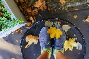 Feet in running shoes in the autumn leaves. Top view. photo