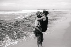 a guy and a girl are kissing on a beach photo