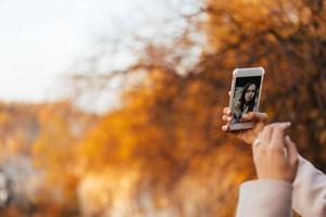 mujer haciendo selfie en el parque de otoño foto