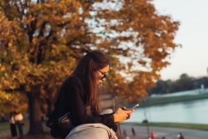 Attractive woman using smartphone outdoors in the park photo