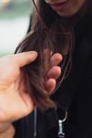 The guy gently holds the girl's hair photo