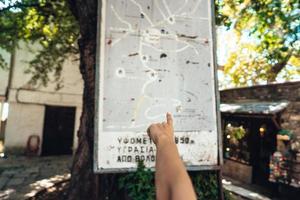 Female hand, points to the map of the city. Makrinitsa photo