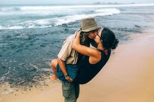 a guy and a girl are kissing on a beach photo