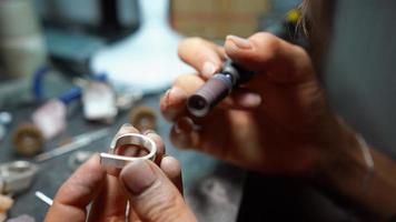 girl master processes the metal plate in the home workshop photo