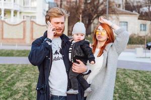 happy mom dad and son hugging in the park photo