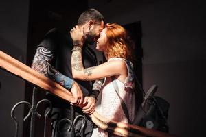 guy and girl are posing on the stairs photo