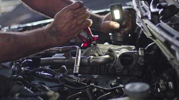 desmontar la bomba turbo del coche con pinzas en las imágenes del taller de reparación. video