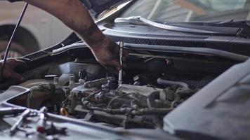 mecánico de automóviles reparando un automóvil con llave de tubo. video