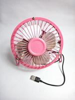 Mini ventilador portátil rosa sobre fondo blanco. foto