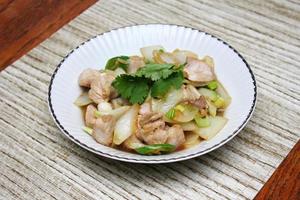 Stir-fried pork with chilli with onions and spring onions served in a white plate, Stir-fried pork with chilli is a popular Thai dish that Thai people eat. photo