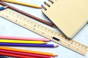 crayones de madera esparcidos sobre la mesa, reglas de madera y cuadernos con el festival de regreso al semestre, los estudiantes van a la escuela, clases de arte. foto