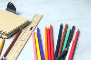 crayones de madera esparcidos sobre la mesa, reglas de madera y cuadernos con el festival de regreso al semestre, los estudiantes van a la escuela, clases de arte. foto