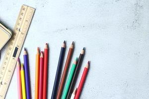 crayones de madera esparcidos sobre la mesa, reglas de madera y cuadernos con el festival de regreso al semestre, los estudiantes van a la escuela, clases de arte. foto