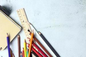 crayones de madera esparcidos sobre la mesa, reglas de madera y cuadernos con el festival de regreso al semestre, los estudiantes van a la escuela, clases de arte. foto