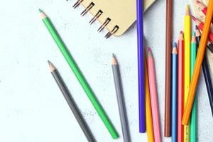 crayones de madera esparcidos sobre la mesa, reglas de madera y cuadernos con el festival de regreso al semestre, los estudiantes van a la escuela, clases de arte. foto