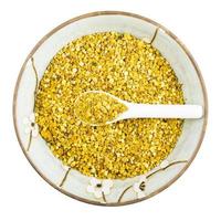 round bowl with ceramic spoon in bee pollen photo