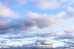 low fluffy gray clouds in blue sky in twilight photo