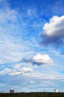 several white cumulus clouds under city photo