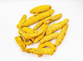 pile of Turmeric Curcuma roots close up on gray photo