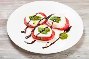 montones de mozzarella, tomate, albahaca con pesto foto