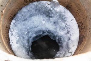 top view of water surface and ice hole in well photo