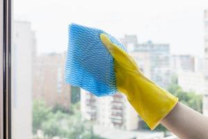 toallitas de mano de cristal de la ventana de la casa con un trapo azul foto