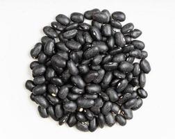 pile of raw black turtle beans close up on gray photo