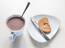 cup with cocoa and toast with peanut butter photo