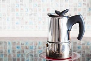 Brewing coffee with moka pot on electric range photo