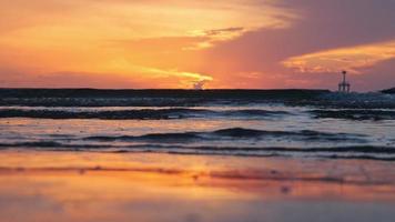 mooi visie van verbazingwekkend zonsondergang Aan de strand. kleurrijk oceaan strand zonsondergang met gouden lucht en zacht golven. zomer vakantie en reizen concept.