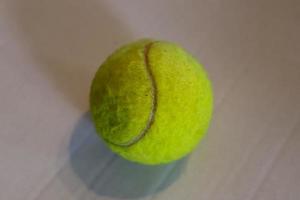Colorful tennis ball in front of a white paper background photo