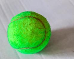 Colorful tennis ball in front of a white paper background photo