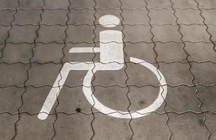 Parking spaces for disabled customers. Parking lot with painted sign of wheelchair. photo