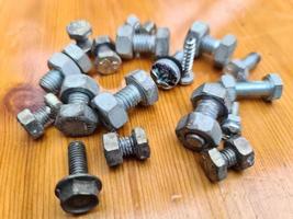 Selective focus shot of screws on a wooden background. photo