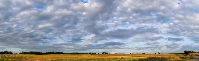 Panorama of stunning clouds in the sky above an agricultural field. photo