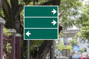 Mockup green road sign with white arrow on footpath photo