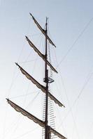 Pirate ship mast on blue sky background photo