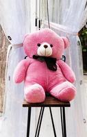 Pink teddy bear on bar stool photo