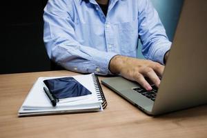 el hombre de negocios puso su mano en la computadora portátil del teclado foto