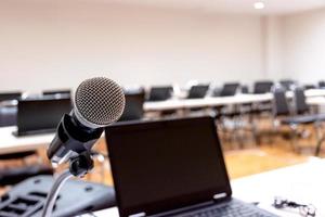 Microphone and laptop on podium stage of speech with copy space in computer classroom photo