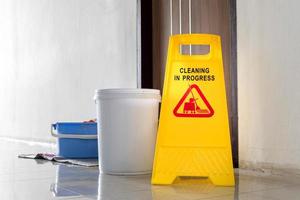 Close up yellow warning sign with message Cleaning in progress photo