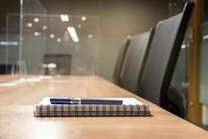 Close up pen and notebook on table in meeting room photo