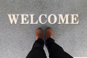Overhead view of man standing on a welcome mat photo