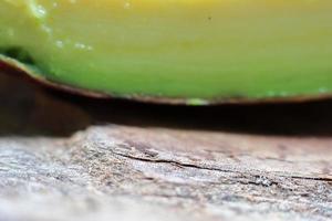 Slices of avocado on wooden background close up picture. Bad cholesterol prevention food photo