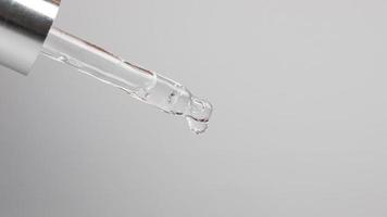 pipette with a drop essential oil on a gray background photo