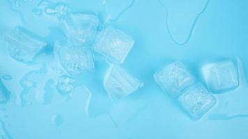 transparent cold fresh ice cubes on blue background photo