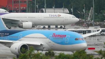 phuket, thailand november 27, 2017 - boeing 787 8 dreamliner av tui, g tuif framställning till ta av från phuket flygplats, thailand. regnig väder, se av de flygplats bana video