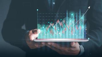 Businessman holding a business analysis tablet Future big data analytics technology concept on VR screen, data management and marketing, business and financial reports to optimize development. photo
